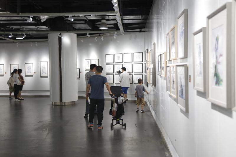 展览吸引来不少年轻父母,带着孩子前来参观