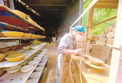 工人给泥坯上土釉