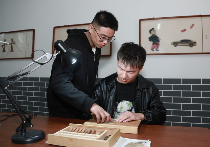 孝义皮影第九代传人赵永期指点皮影雕刻