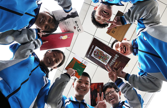 ▲新绛县横桥中学中学生在开心展示获赠的正版“护苗”图书