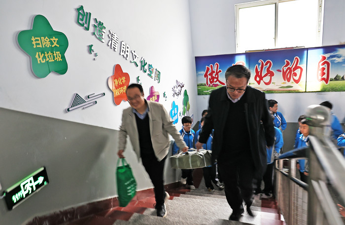 ▲县委宣传部、新华书店、网信办等工作人员搬运赠送的“护苗”图书