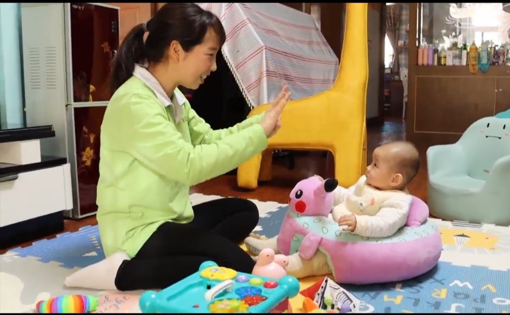 月嫂司静云在陪小朋友做游戏。