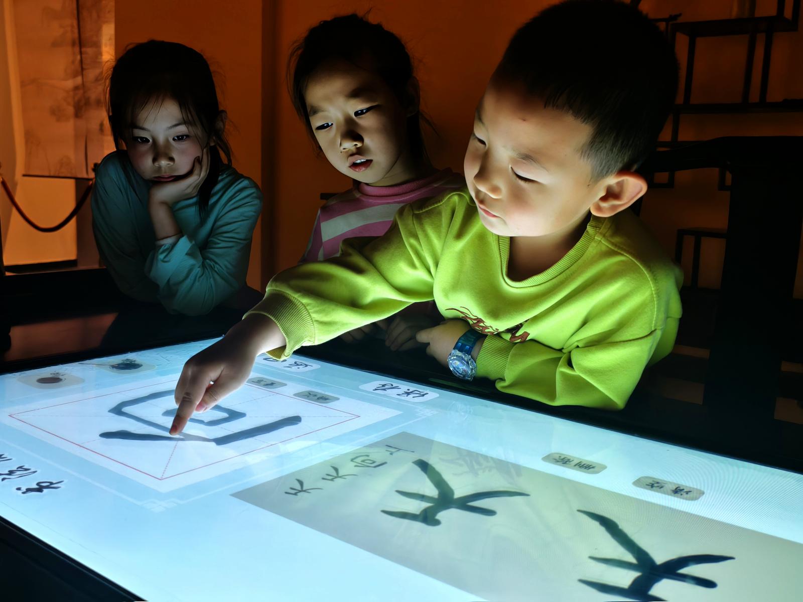 小朋友在太原博物馆体验通过数字科技生成书法艺术带来的乐趣