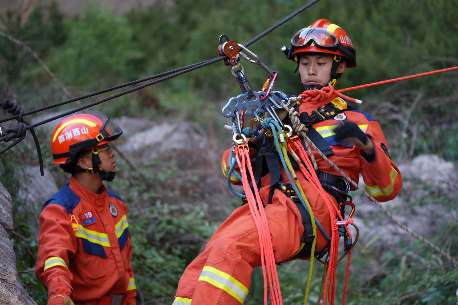 消防救援人员运用绳索系统降至悬崖底部。