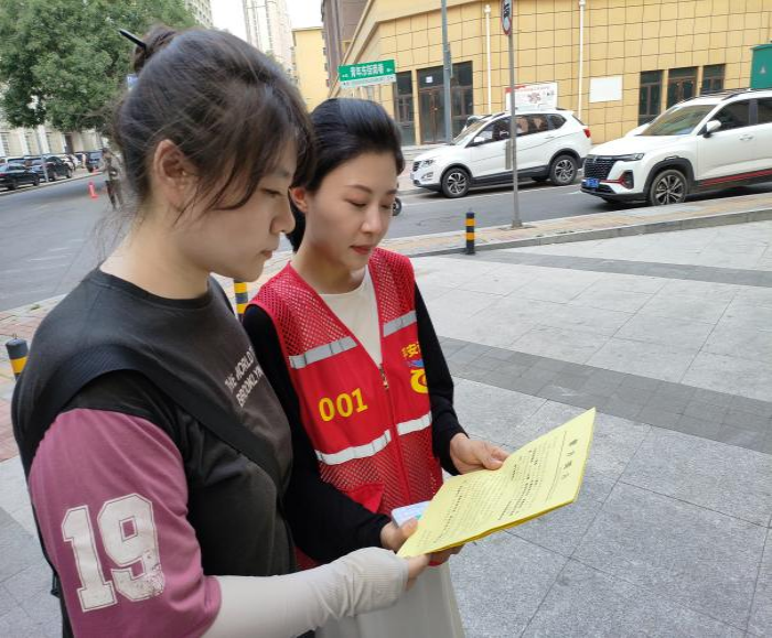 工作人员为居民发放反诈传单