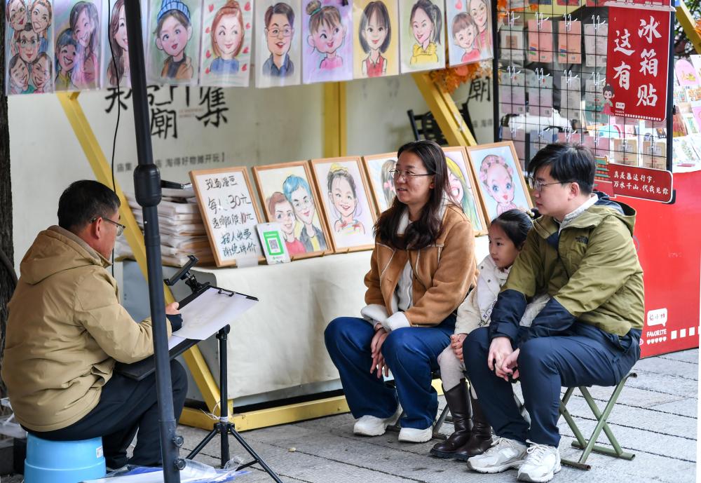 在忻州古城,商户为游客画肖像漫画(10月25日摄)。