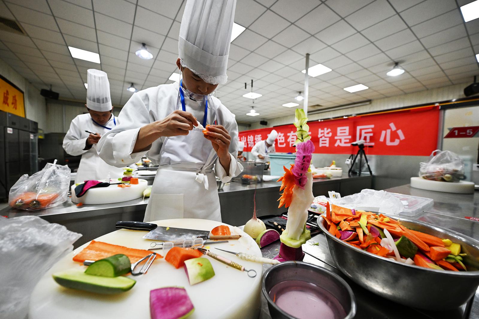 11月18日,参加烹饪技能大赛的学生正在精心制作美味佳肴。