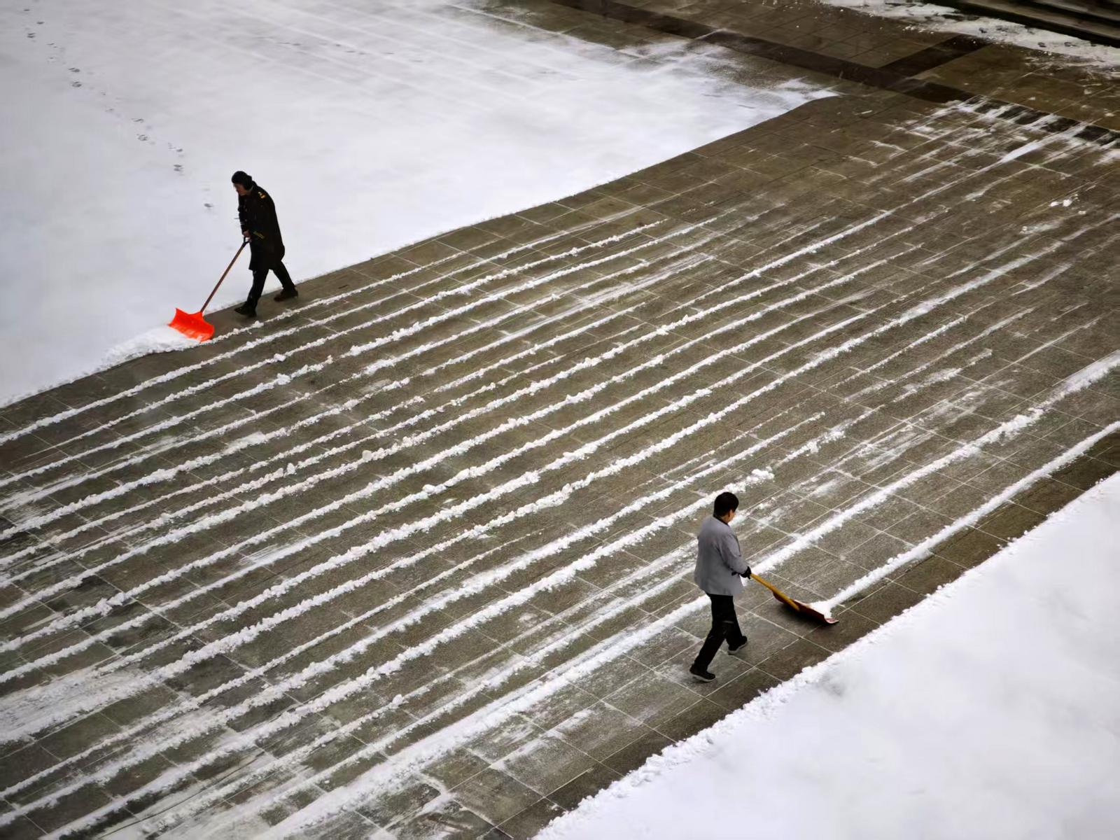太原市综改区物业人员清理积雪。王也 摄