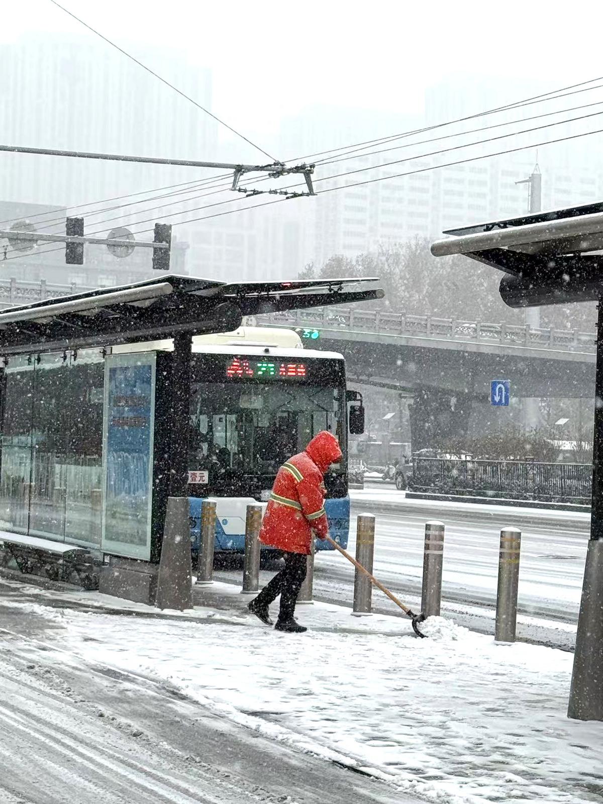 太原市环卫工人在公交站台清理积雪。卫波 摄