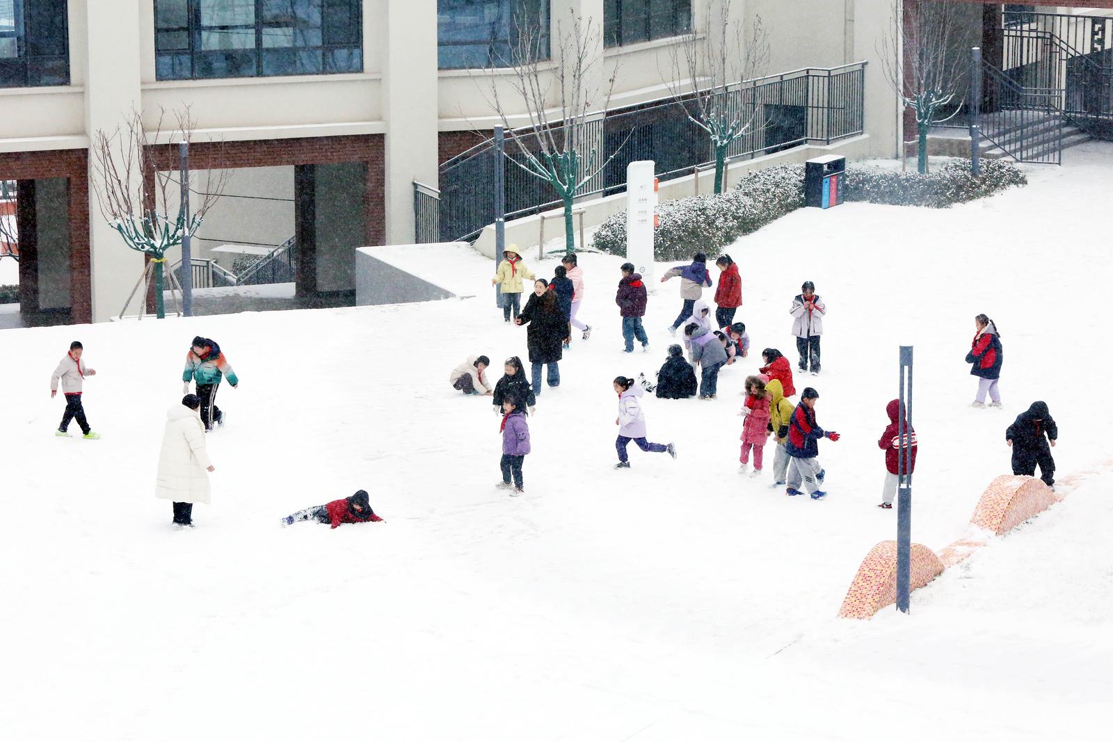 太原市迎泽区仁杰小学,孩子们在雪中嬉戏。田志忠 摄