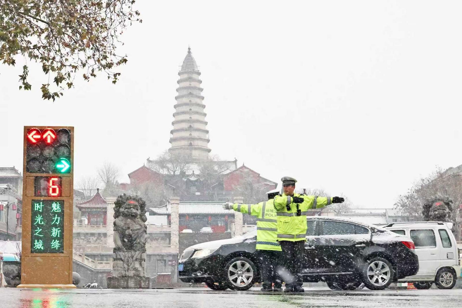 运城市新绛县交警在雪中疏导交通。高新生 摄