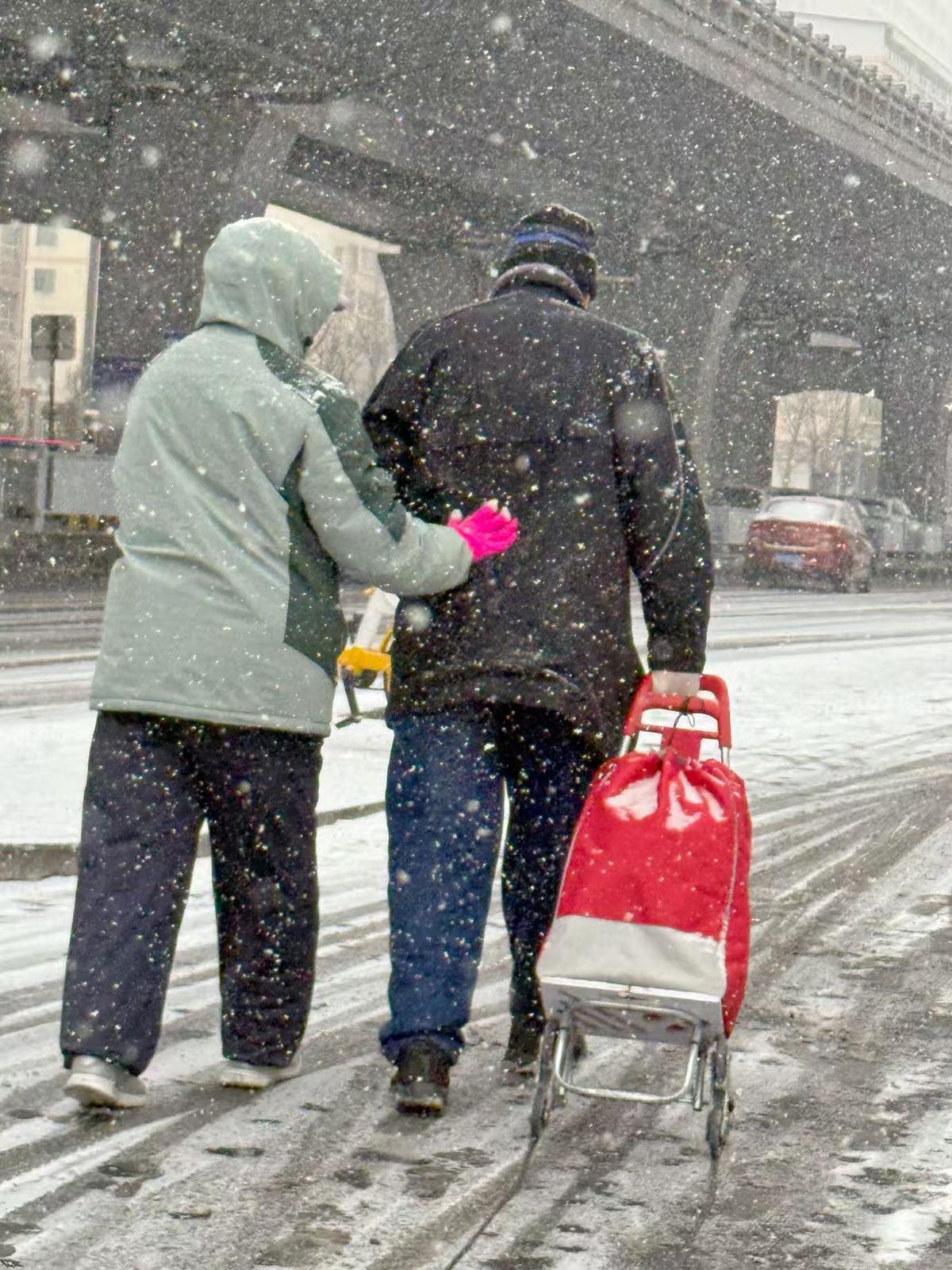 太原市迎泽区双塔寺街,一对老人在雪中搀扶前行。卫波 摄