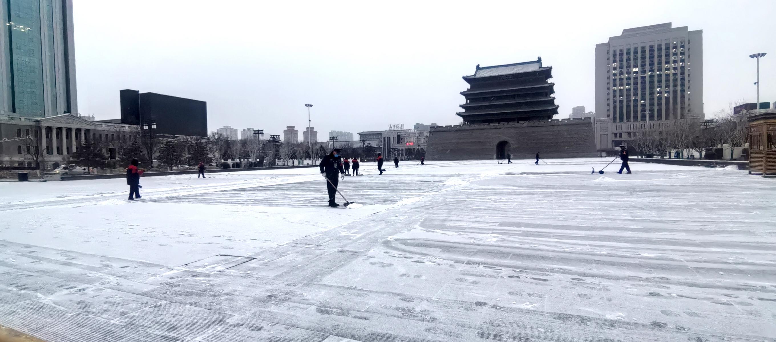 太原五一广场,工作人员清理积雪。王强 摄
