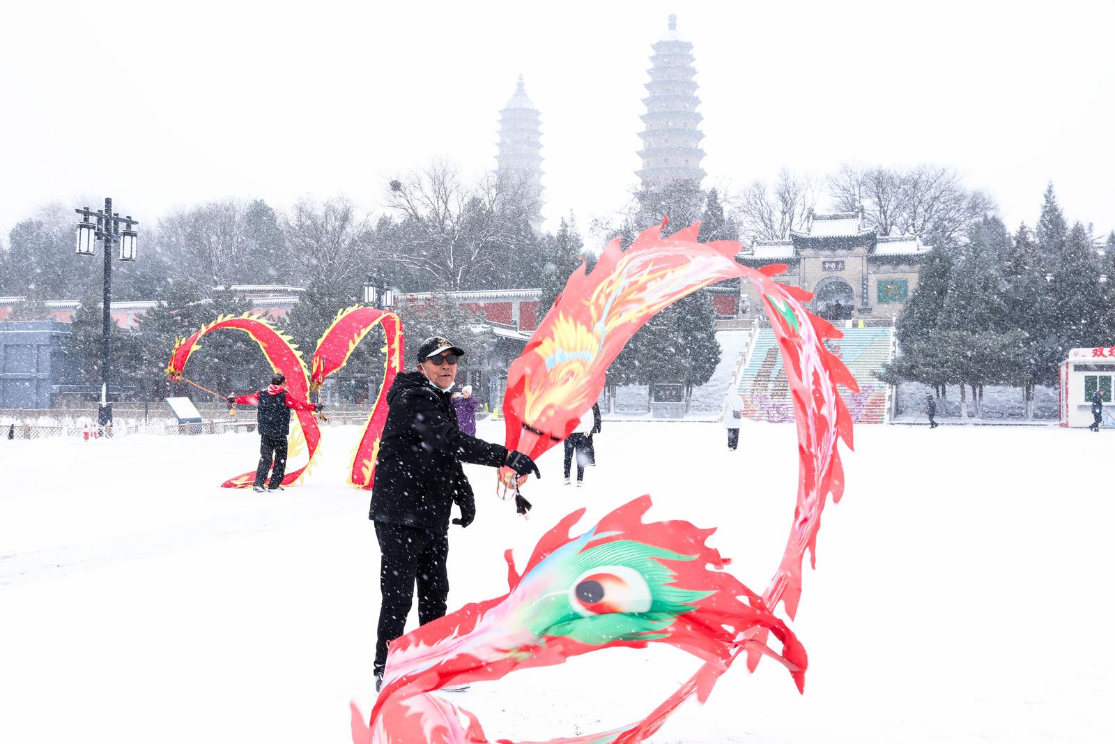 太原市双塔公园,市民在雪中“舞龙”。杨杰 摄