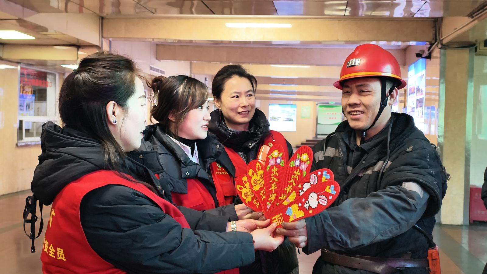 2026年1月1日,新年的第一缕阳光升起,阳泉华阳二矿工会女职委的家属协管员将一针一线缝纳而成的红色鞋垫送到矿工手中。杜爱清 摄