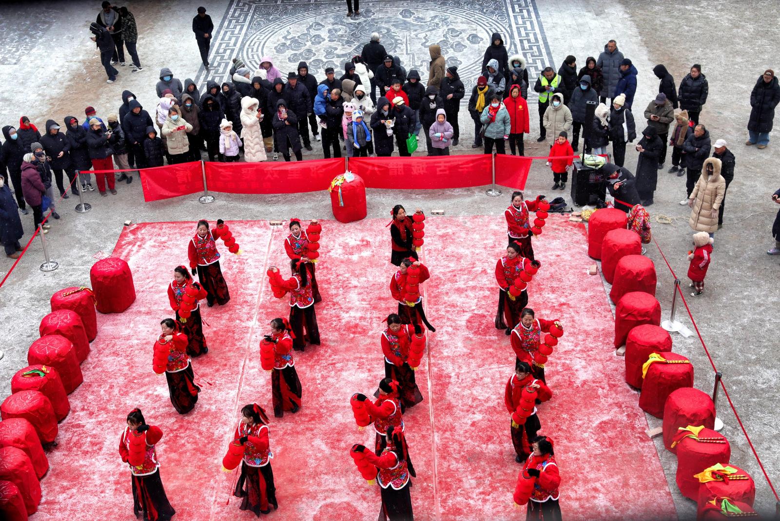 1月25日,晋中市太谷县古城县衙广场,民间文艺表演团队雪中为游客表演灯笼舞。