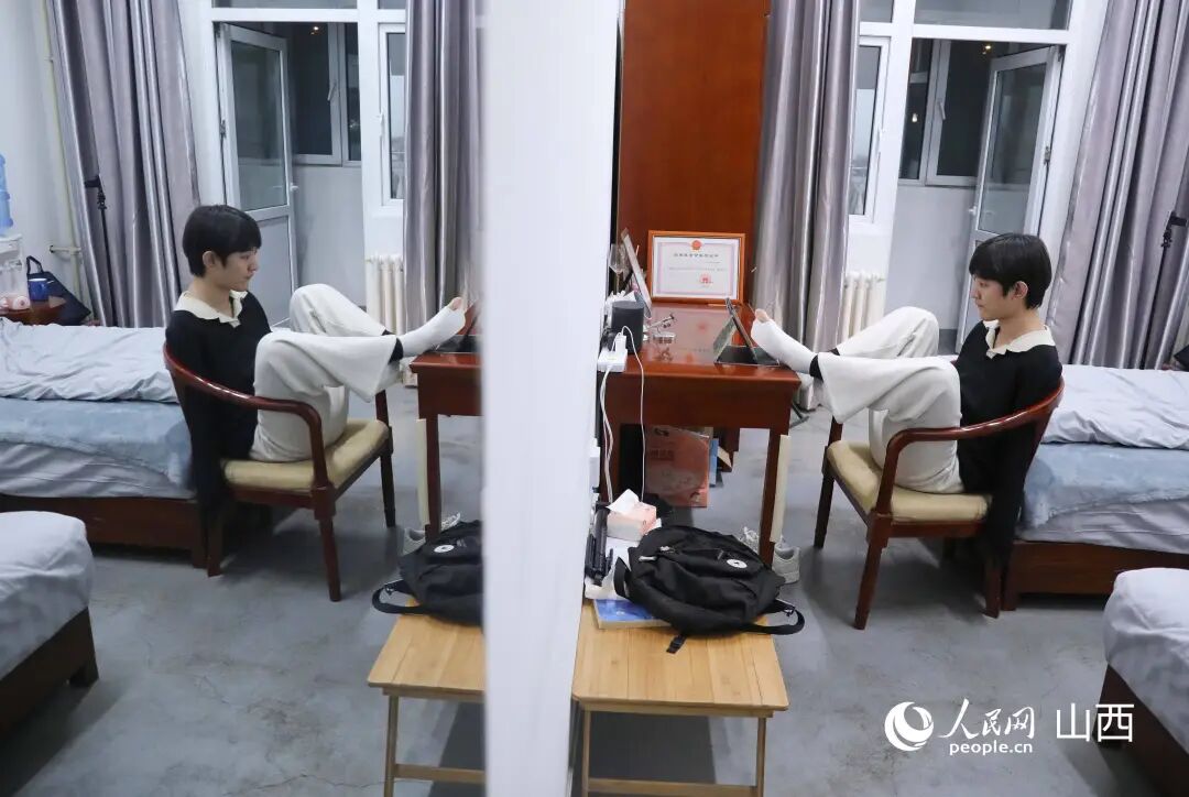 王海港在学校提供的单人间宿舍内忙碌。人民网记者 王帆摄