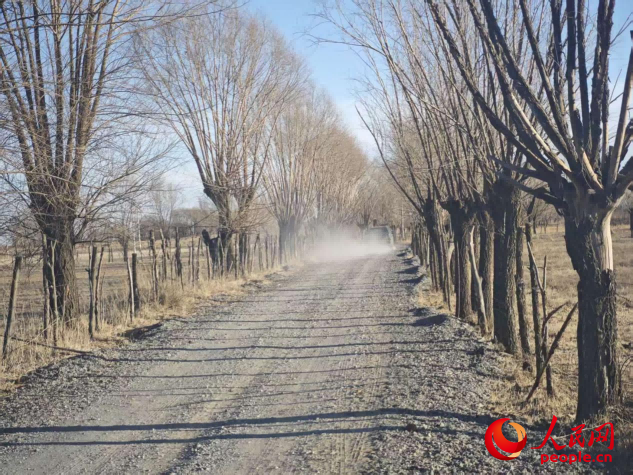 煤矸石道路上，车过后粉尘四起。人民网记者 黄钰摄