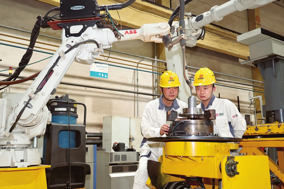 全国技术能手王大龙和杜家伟在生产现场讨论焊接技术改进方案。山西日报通讯员摄