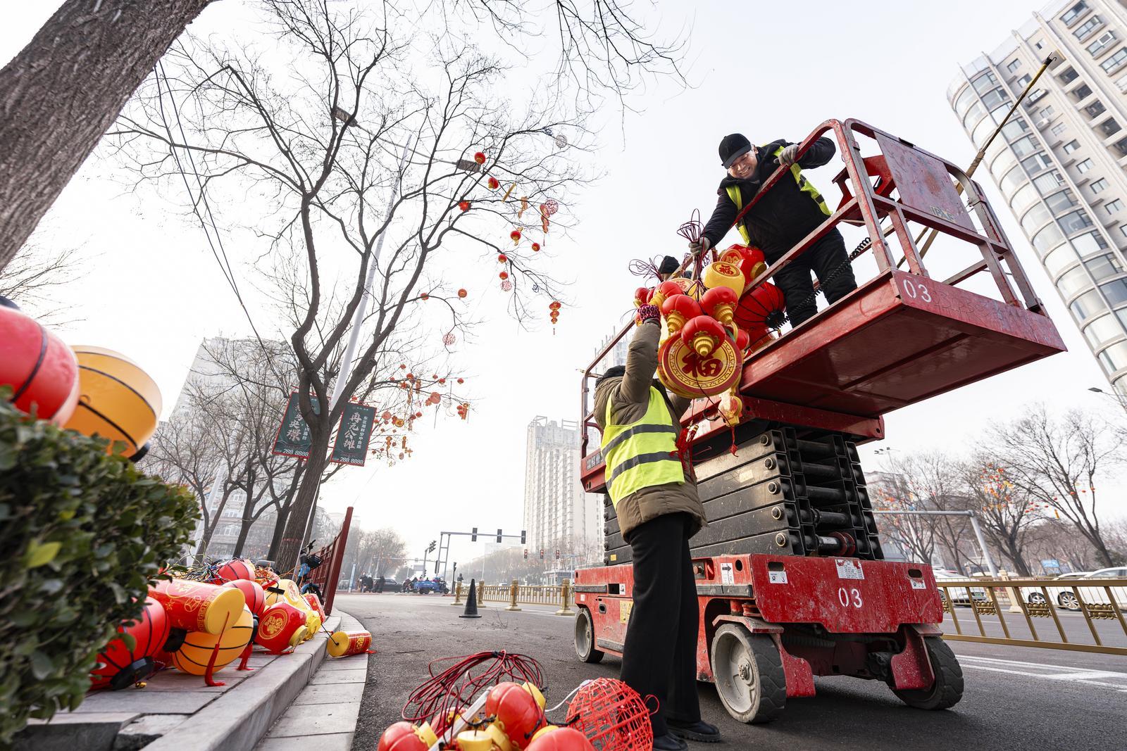 运城市工人们将彩灯悬挂于道路两旁。 兰立强 摄