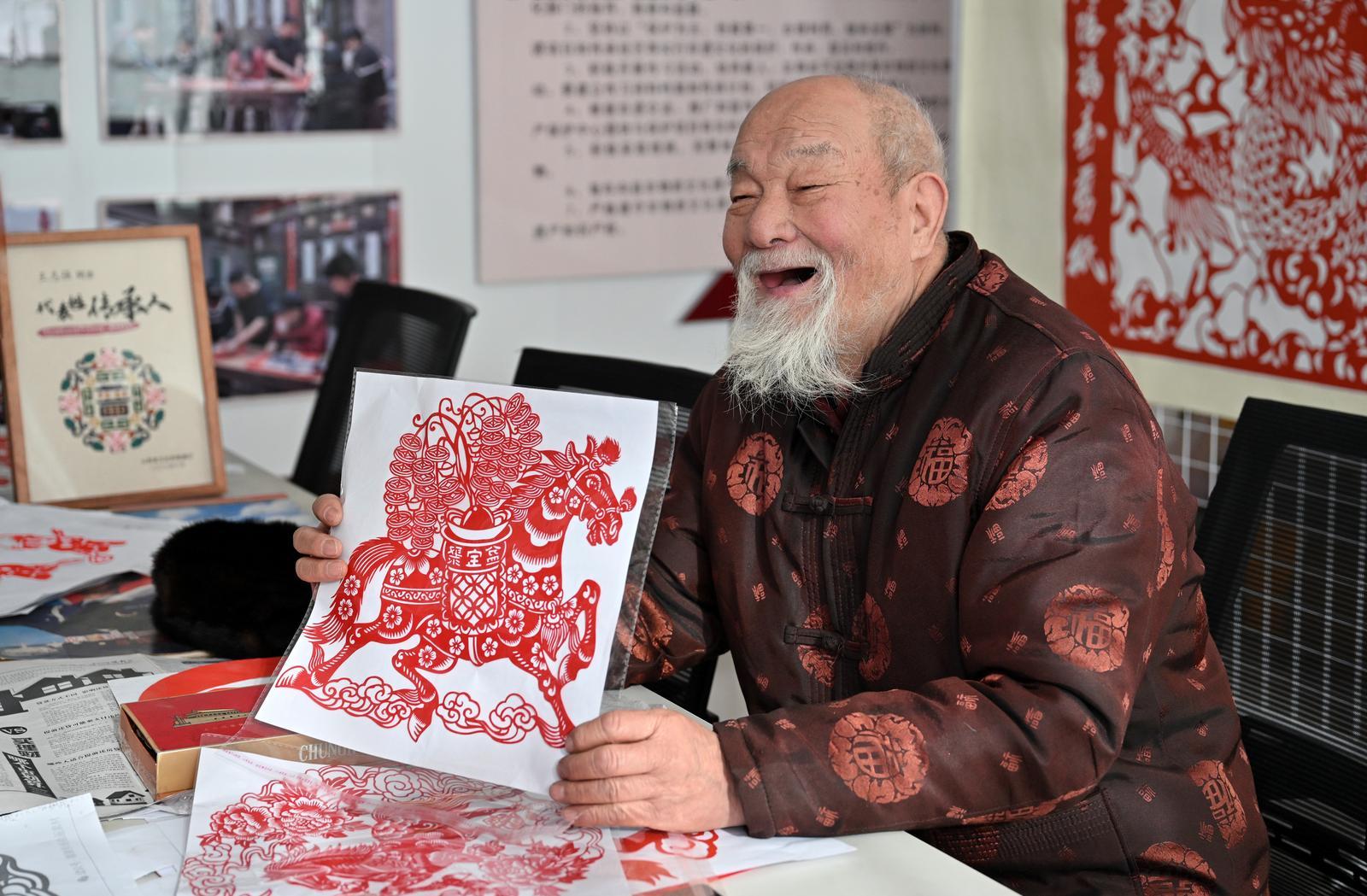 晋中市寿阳县非遗“寿阳福寿剪纸”传承人王森玉展示马年生肖剪纸。 原海春 摄