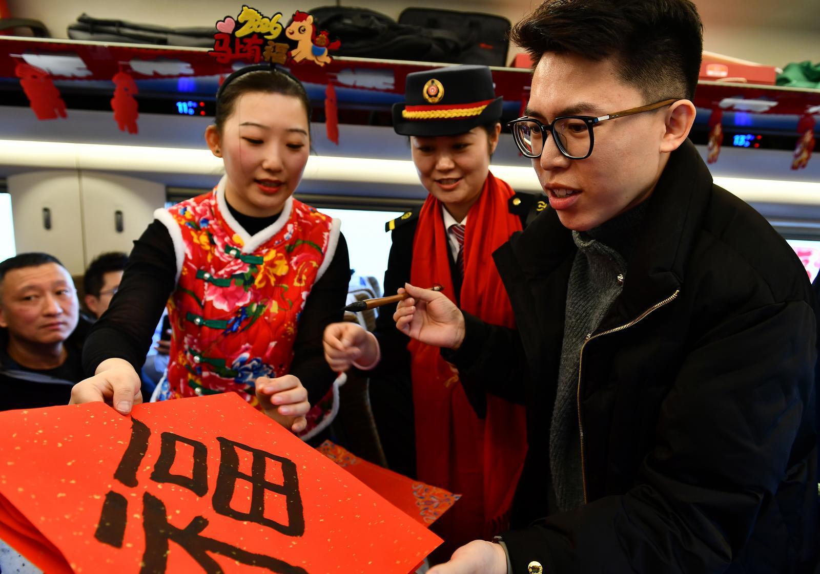 2月2日,G380复兴号上,乘客们参与列车乘务组准备的新春节目。 高万军 摄
