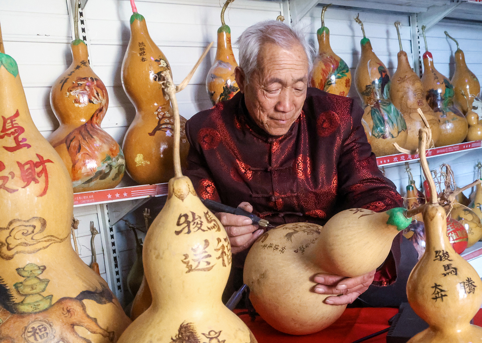 2月2日,运城市非遗传承人吴从礼精心创作葫芦烙画。 李克荣 摄
