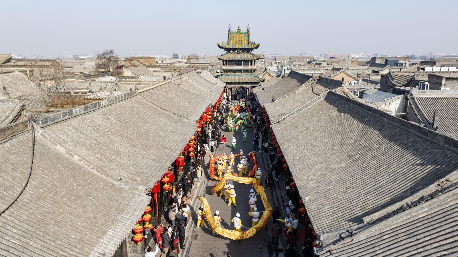 2月17日,平遥古城南大街,舞龙社火表演吸引游客驻足观看、互动。王疆华 摄
