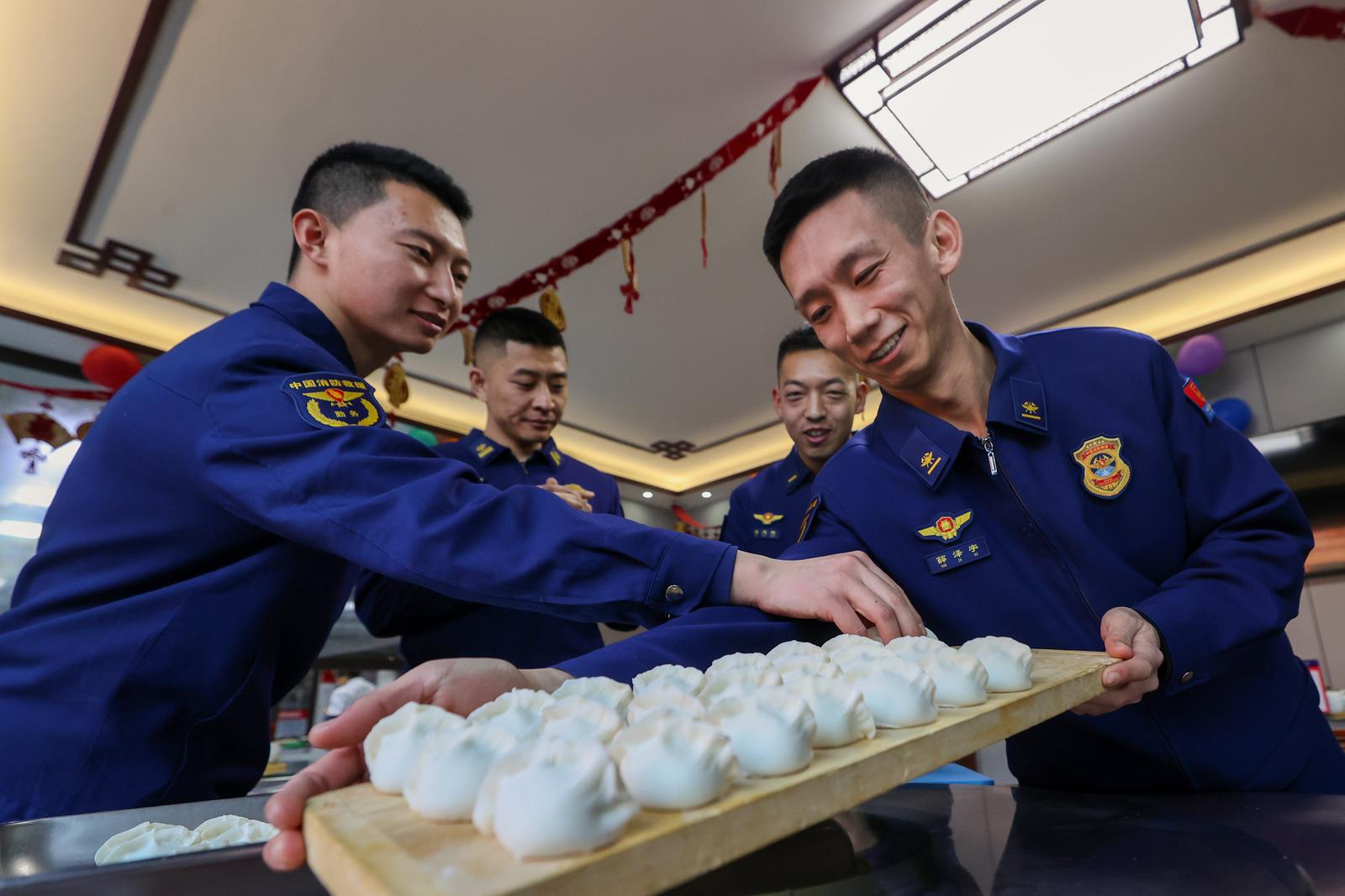 2月17日,大同市消防救援站里热气腾腾,消防员围坐一桌包饺子。申辉 摄