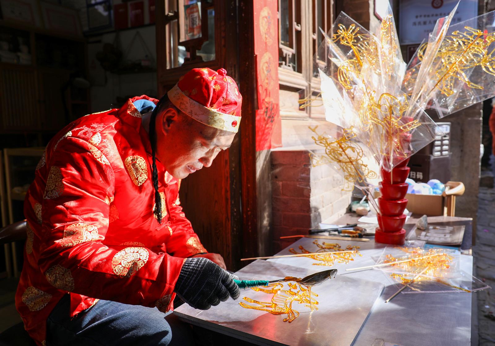 春节期间,介休市张壁古堡民间艺人用糖丝绘出马年生肖糖画。 任增远 摄