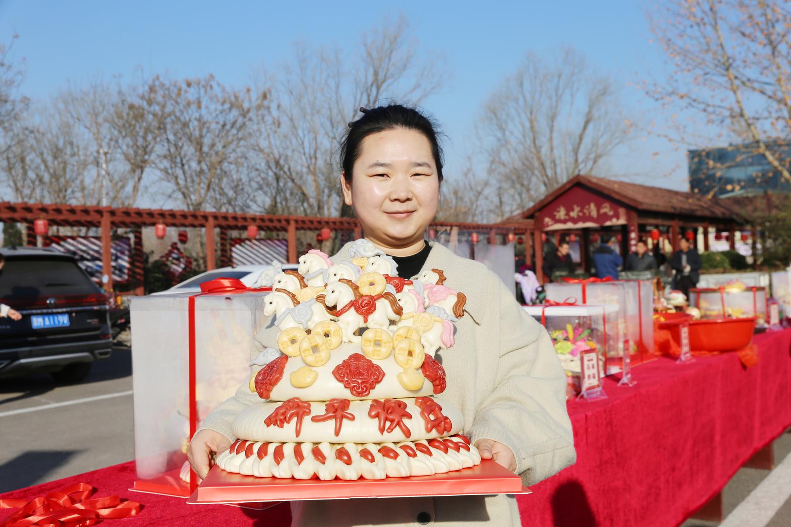 在运城市夏县水头镇举办的第七届花馍文化节上,非遗花馍传承人姜莎展示其作品《八骏图》。张秀峰 摄
