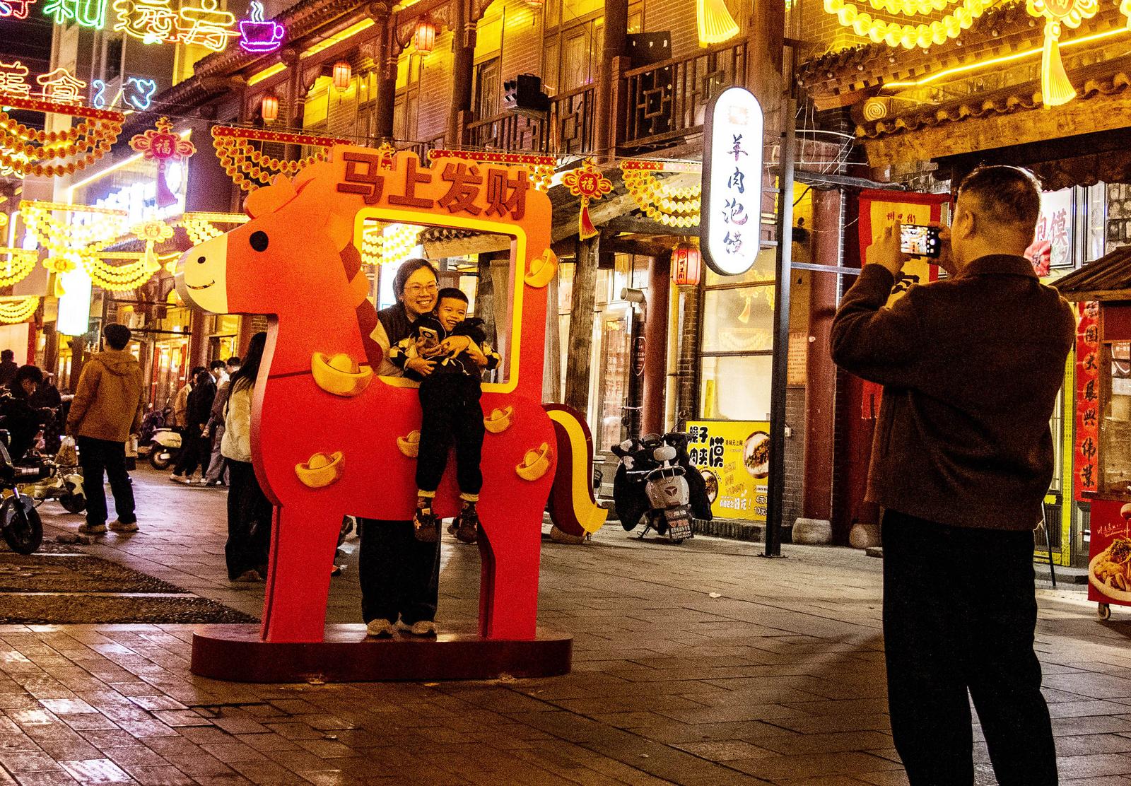 2月20日晚,游客在霍州市州里街马年造型前打卡。田红萍 摄