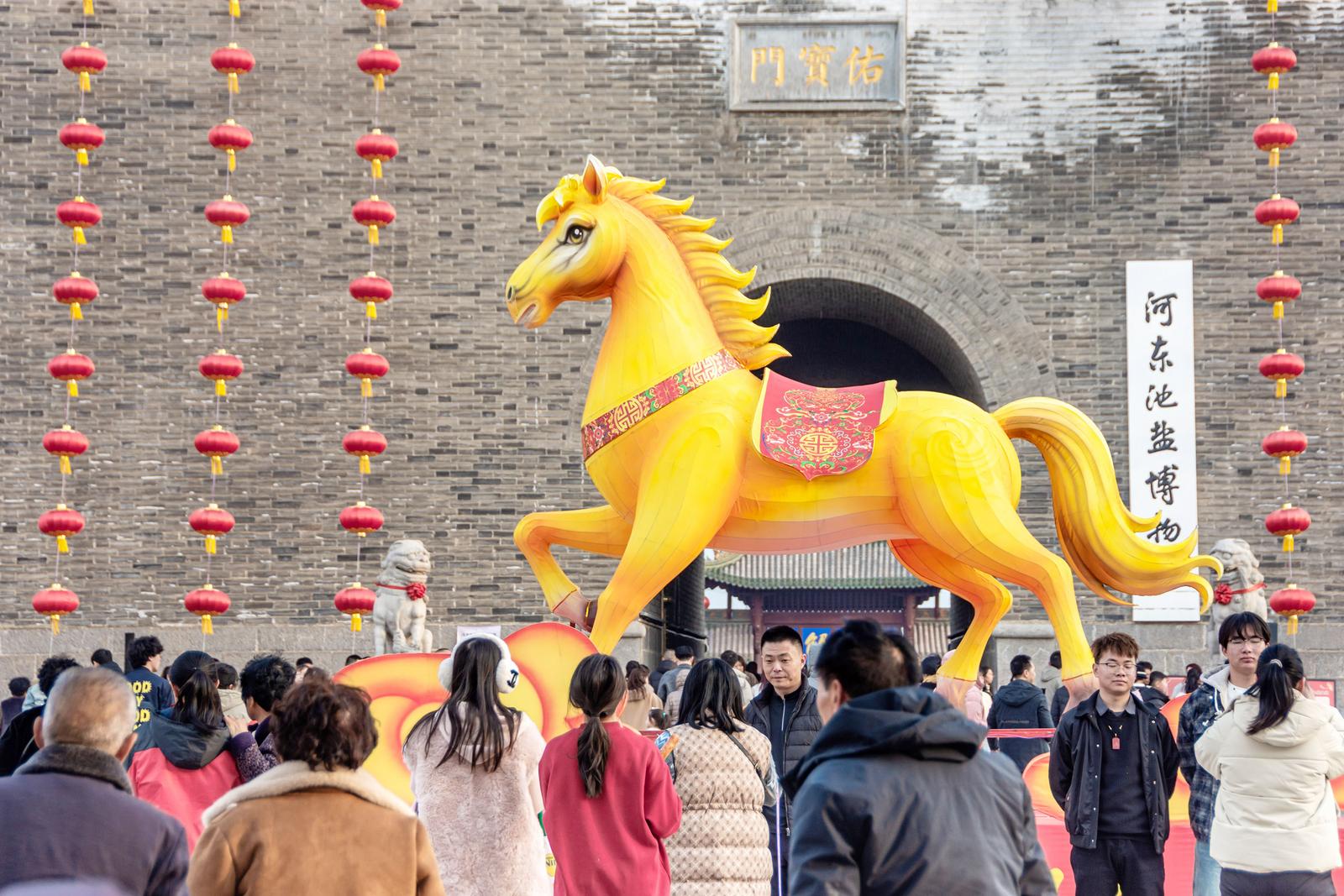 金马迎春至,福气满人间。运城市盐湖区中禁门广场,红红的灯笼和金色的骏马雕塑引人注目。姜世忠 摄