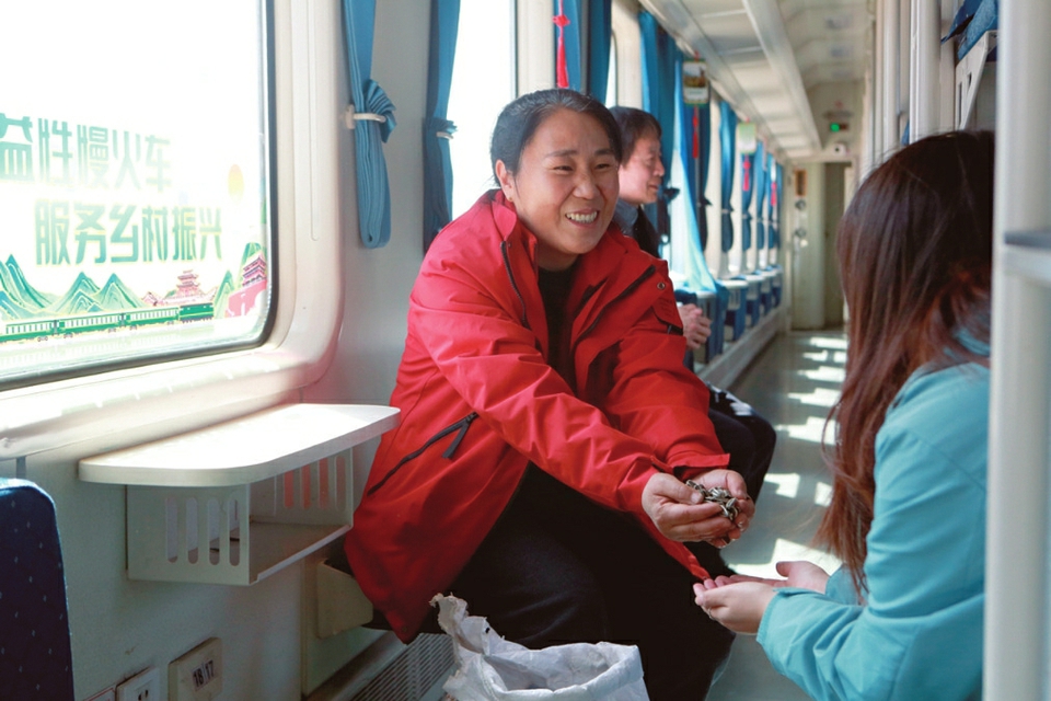 村民杨翠珍与同车乡亲分享自种的葵花籽。