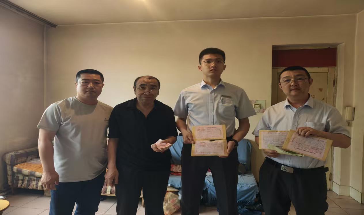 工作人员清点残币后,将兑换的新币交给王大爷。